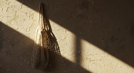 Textured Wall with Hanging Net Bag and Dramatic Sunlight Shadows
