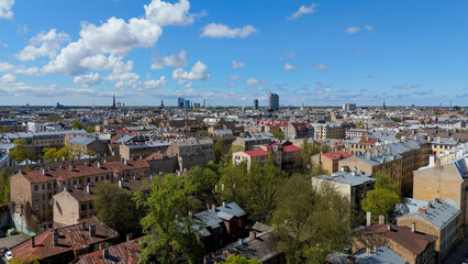 Obraz premium Aerial Drone View Of Riga Panorama In Latvia On A Sunny Spring Day Showcasing The Rooftops Of Houses The Vibrant City Center Historic Buildings And Barona Street Playground of the Downtown Sports Area