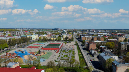 Aerial Drone View Of Riga Panorama In Latvia On A Sunny Spring Day Showcasing The Rooftops Of Houses The Vibrant City Center Historic Buildings And Barona Street Playground of the Downtown Sports Area