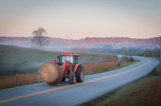 Rural Kentucky Autumn Morning: Tractor Transporting Hay Bale on