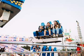 Big kids riding carnival ride at county fair on evening outing