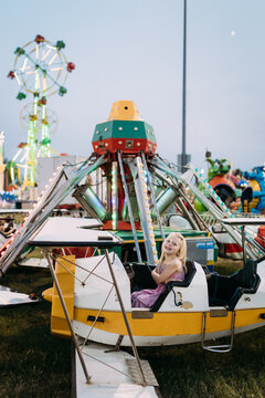 Child on colorful airplane carnival ride at fair
