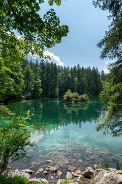 Badersee lake in Bavaria, Germany, with clear water and lush green forest in summer