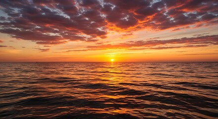 Vibrant sunset over ocean with fiery sky and water reflections