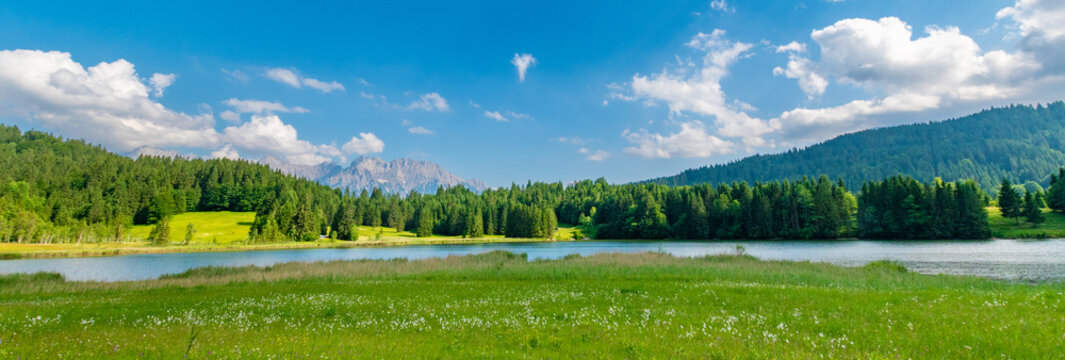 Geroldsee (Wagenbr&uuml;chsee) in Bavaria, Germany, with alpine meadow, forest and mountains under blue sky