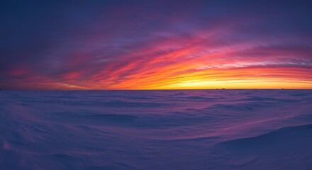 Vibrant sunset sky over a vast snowy landscape with a panoramic view