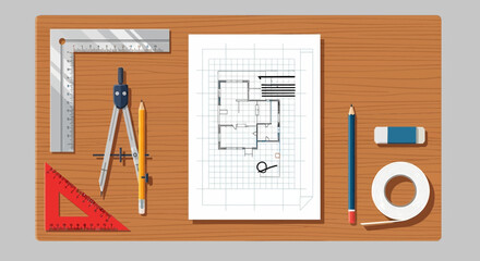 Blueprint and drafting tools on a wooden surface.