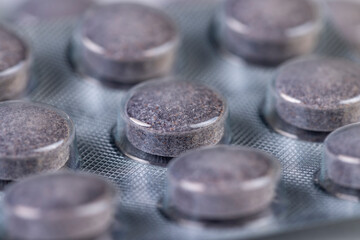 cylindrical purple tablets made from natural ingredients packed in a blister , whole purple tablets packed in a plastic blister with the addition of blueberry extract and other ingredients