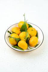 Tangerines in a bowl, light background, close-up, winter fruits.