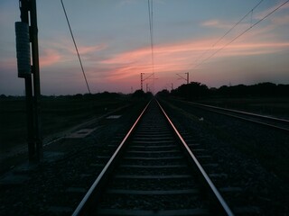 Endless symmetrical railway track in sunset