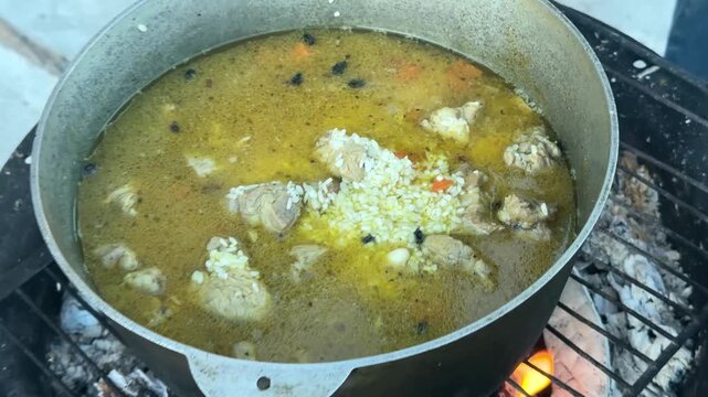 cooking pilaf over a fire in a cauldron. High quality 4k footage