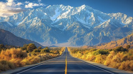 Naklejka premium Desert Road with Snow - Capped Mountains in the Distance