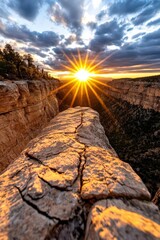 The sun setting over a rugged canyon, casting deep shadows and golden highlights