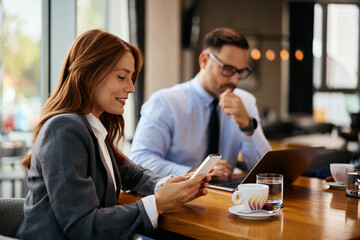 Fototapeta premium Happy businesswoman using smart phone in cafe.