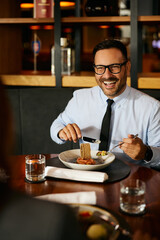 Happy businessman enjoying in lunch with colleague in restaurant.