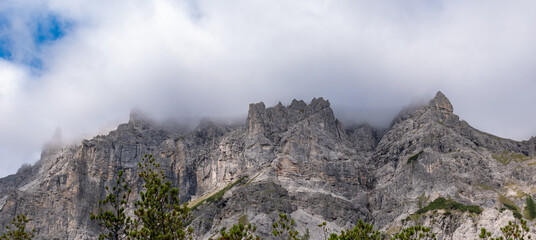Alpine mountain peaks emerging above a drifting cloud layer