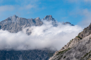 Alpine mountain peaks emerging above a drifting cloud layer