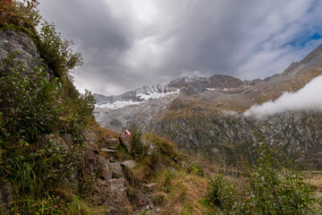 Alpine hiking trail in the Zillertal Alps with view towards the Schlegeiskees glacier, rugged mountain landscape, dramatic clouds and rocky terrain in the Austrian Alps