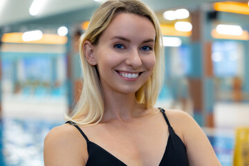 Smiling woman posing near swimming pool