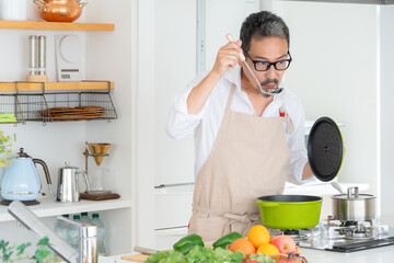 キッチンで料理をするミドルの夫婦