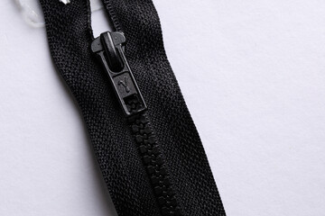 Black zipper fastened on a light background, macro © Mariia