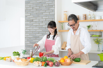 キッチンで料理をするミドルの夫婦