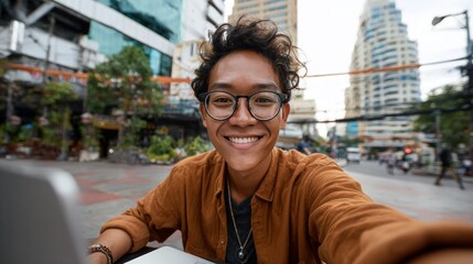 Young man smiling at camera in city street setting.