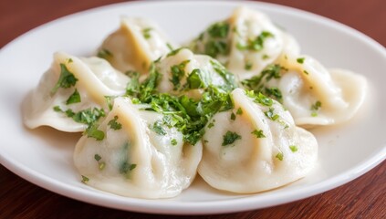 Delicious dumplings on a white plate, garnished with fresh herbs.