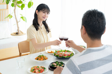 リビングで食事をするミドルの夫婦