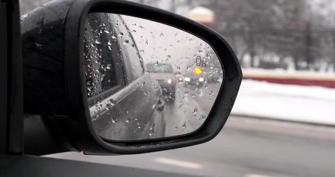 Blind spot monitoring icon on the mirror of a modern car