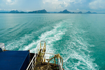Ferry and Ferry pier near Koh Phangan island in Thailand. The rear of Ferries transport passengers. The beautiful scenery turquoise sea. Big ferry ship with Thai flag turning at the sea and sails.