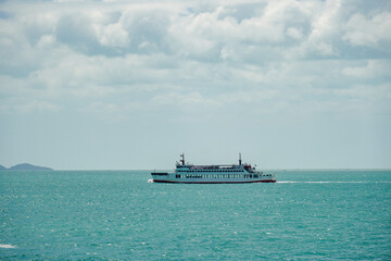 Ferry and Ferry pier near Koh Phangan island in Thailand. The rear of Ferries transport passengers. The beautiful scenery turquoise sea. Big ferry ship with Thai flag turning at the sea and sails.