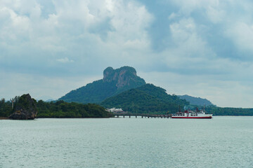 Ferry and Ferry pier near Koh Phangan island in Thailand. The rear of Ferries transport passengers. The beautiful scenery turquoise sea. Big ferry ship with Thai flag turning at the sea and sails.