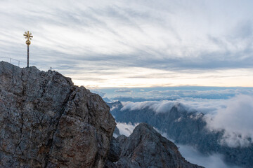 Blue hour above a sea of clouds at the Zugspitze, rugged alpine rock formations and dramatic evening sky creating a serene high mountain atmosphere