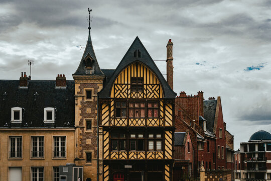 Street-level view of Amiens historical buildings, France, rising above traditional houses, capturing medieval architecture against a clear blue sky.