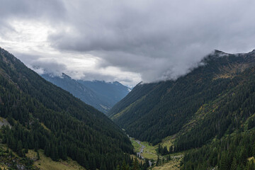 mountain valley with low rain clouds on top view from ascending surrounded by two forests