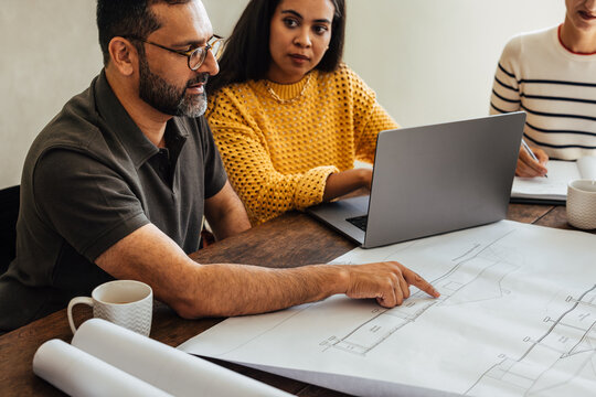 Team of architects discussing building plans during a collaborative design meeting