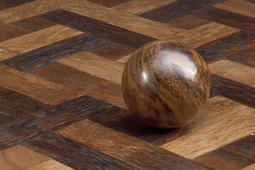 Elegant wooden sphere resting on intricate herringbone-patterned flooring highlighting warm earthy tones and rich textures that evoke a sense of luxury and craftsmanship in interior design