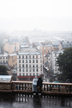Couple Watching the Rainy Paris Skyline from a Balcony in Montmartre