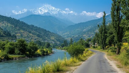 Naklejka premium Serene Valley Road Winding Through Green Mountain Landscape with Snow Capped Peaks under Bright Sky