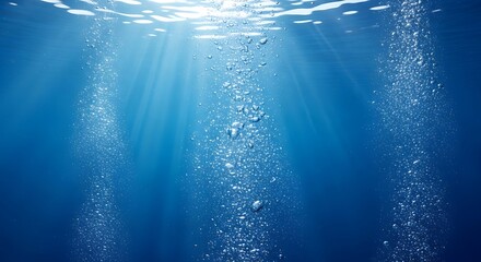 Underwater view with sunbeams piercing the deep blue water, illuminating rising columns of air bubbles