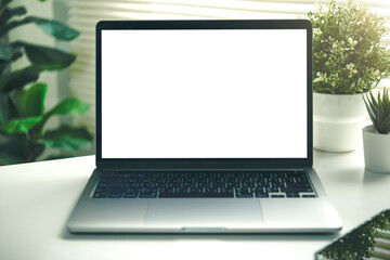 Laptop mockup with blank white screen on a green round table in window light. home office scene for UI previews, web banners, presentations, and product marketing.
