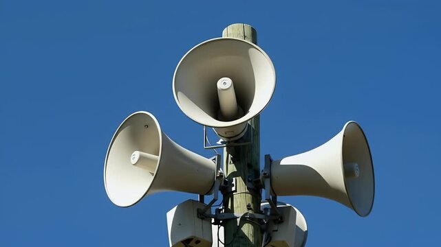 Emergency Siren Loudspeaker System Mounted on Pole Against Blue Sky.