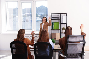 Woman waving goodbye to her colleagues in office
