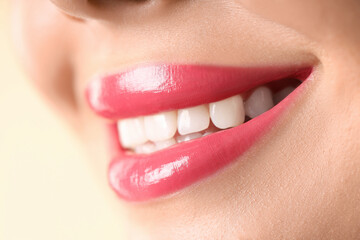 Fototapeta premium Woman with beautiful pink lipstick on her lips against beige background, macro view