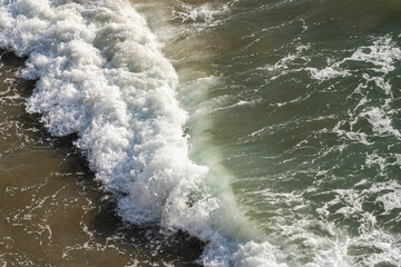 Wave on the shore from above the ocean