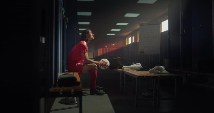Focused Male Athlete Sitting Alone with a Soccer Ball in His Hands, Lost in Thought as He Prepares for the Game. Cinematic Moment of Concentration, Discipline and Dedication to the Sport