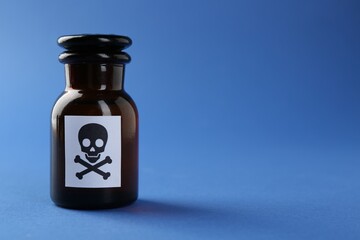 Bottle of poison with warning sign on light blue background, closeup. Space for text