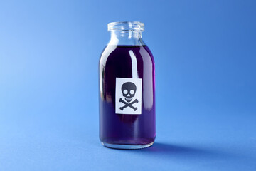 Bottle of poison with warning sign on light blue background, closeup