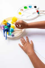 Child engaged in creative painting with sponge brushes and vibrant colors